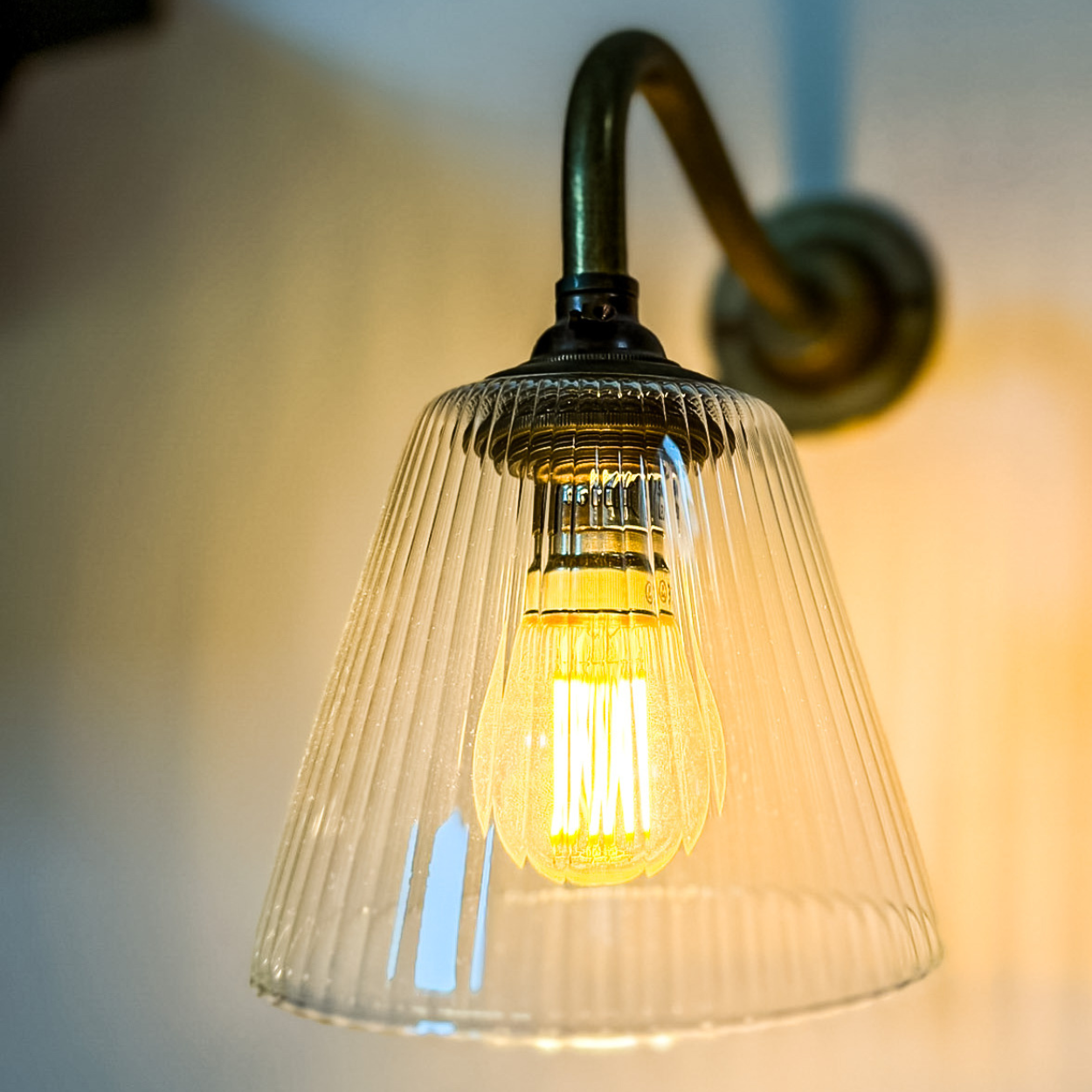 Wall sconce with ribbed glass shade, close detail